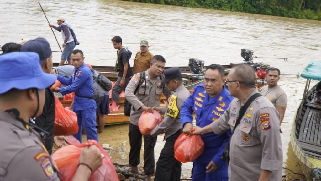 Polda Riau Terjang Arus Sungai Kampar Guna Salurkan Ratusan Bansos