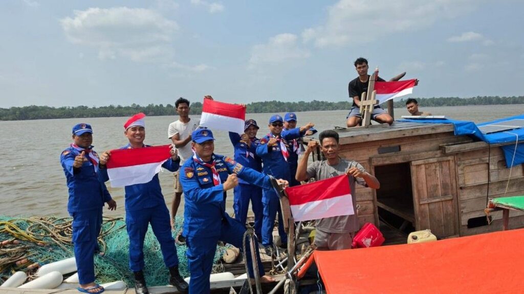 Polres Pelalawan Bagikan Bendera dan Bansos Kepada Nelayan Kuala Kampar