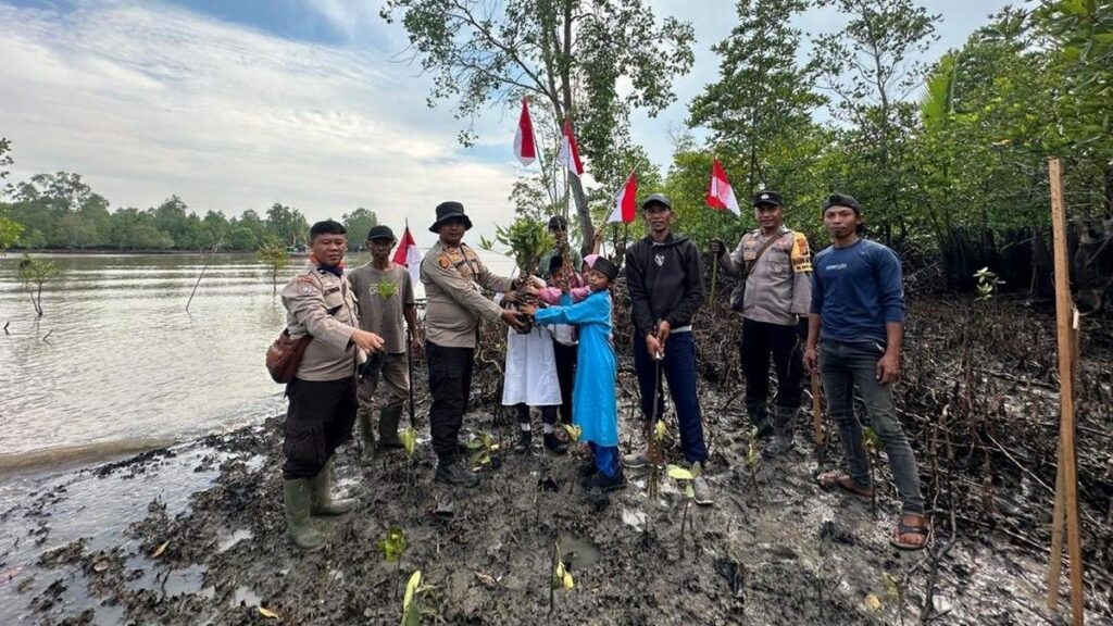 Polres Dumai Pasang Bendera di Kapal Nelayan dan Sekolah Pesisir